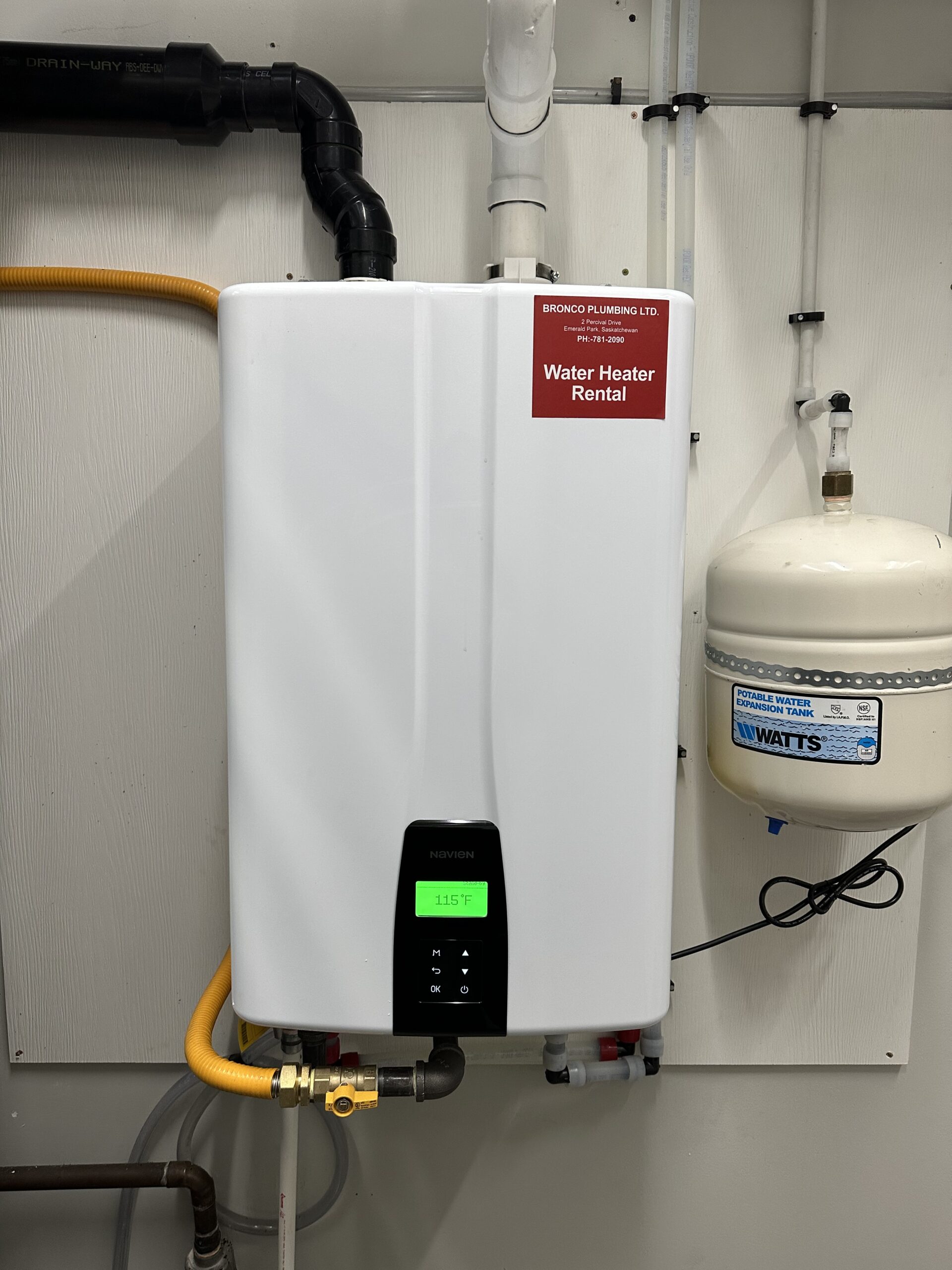 Three sleek water heaters mounted on a wall in a contemporary kitchen, showcasing elegant design and functionality.